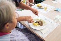 awo_archiv_tag_07_0911_pflegerin_schneidet_essen_auf_teller.jpg