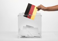 person-putting-germany-flag-card-into-ballot-box.jpg